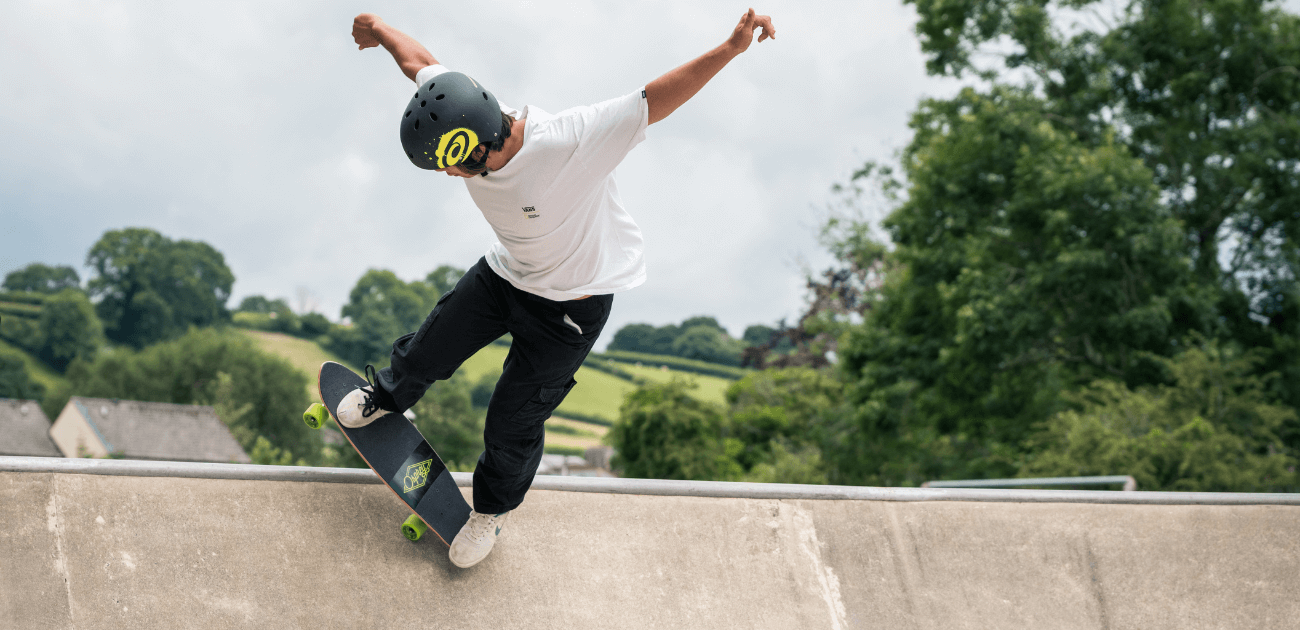 Young skateboarder riding in a skatepark, demonstrating easy skateboarding tricks for beginners.